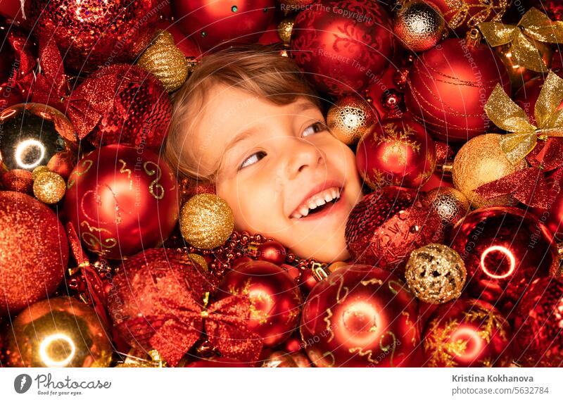 Kleinkind Jungen Gesicht leuchtet mit Freude in roten Weihnachtsbaum Spielzeug Kugeln. Feiertag. Ball Kind Neujahr Kinder Dekoration & Verzierung heimwärts