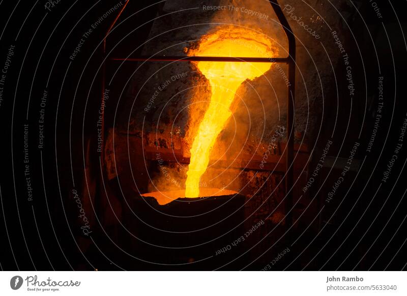 Prozess der Befüllung einer Pfanne mit geschmolzenem, heißem Stahl aus einem Ofen mit Rauch - Nahaufnahme mit selektivem Fokus Brotbelag fließen industriell