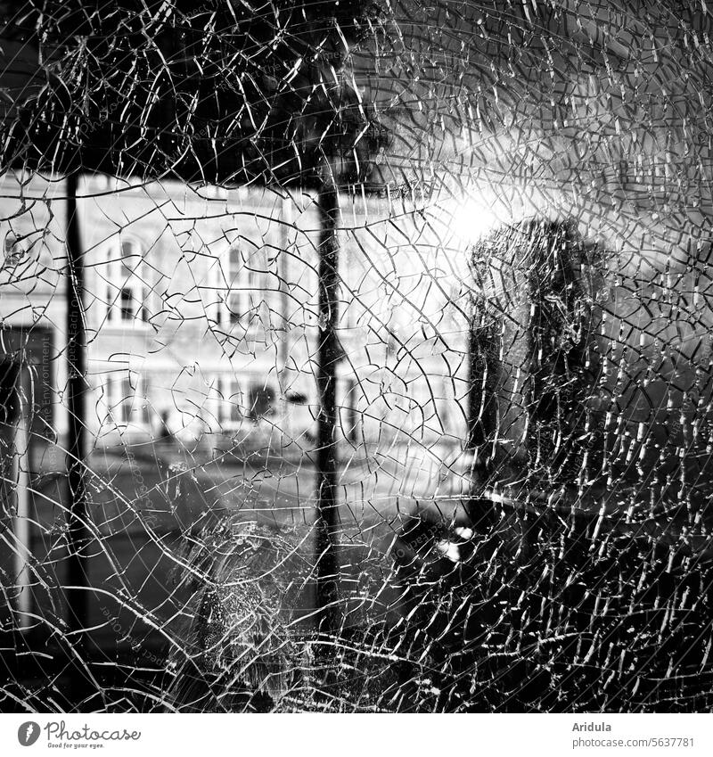 Risse in einer Glasscheibe vor Hausfassade Scheibe kaputt Fenster Zerstörung Vandalismus Schaden Strukturen & Formen Aggression Gewalt Detailaufnahme