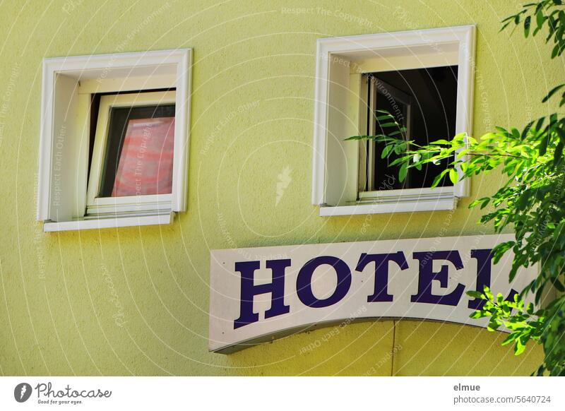 Schriftzug  HOTEL  an der grünen Gebäudewand mit zwei Fenstern Hotel Übernachtungsmöglichkeit Unterkunft Schild Reisen Tourismus Herberge Zimmervermittlung