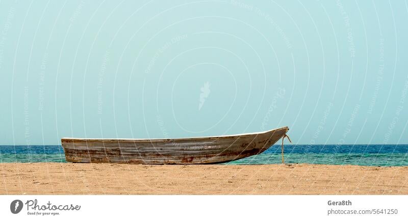 altes Boot auf dem Sand gegen das Meer Rotes Meer Hintergrund Strand blau Küste Farbe Tag dreckig Fischer Fischerboot Fischen Horizont Landschaft Natur Nervös