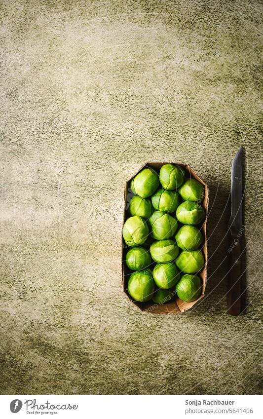Frische Kohlsprossen in einem Karton auf einem grünen Tisch. Draufsicht. frisch roh Lebensmittel Gemüse Gesundheit organisch reif Diät natürlich