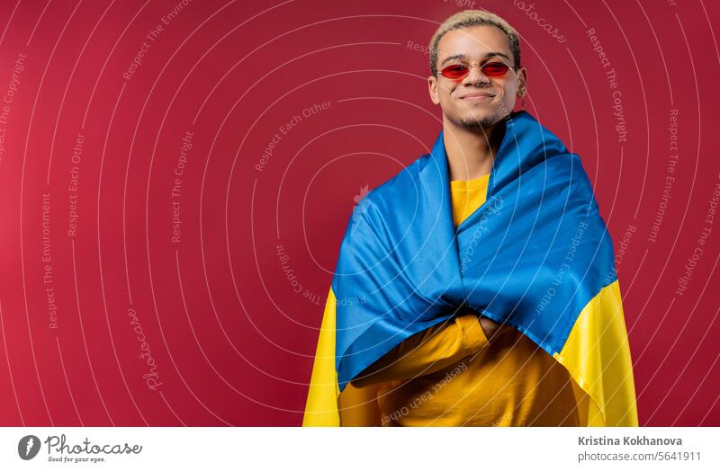 Superman mit ukrainischer Nationalflagge. Ukraine, Patriot, Sieg Krieg Feier Transparente schön zu feiern heiter clever Kultur lockig behaart osteuropa Bildung