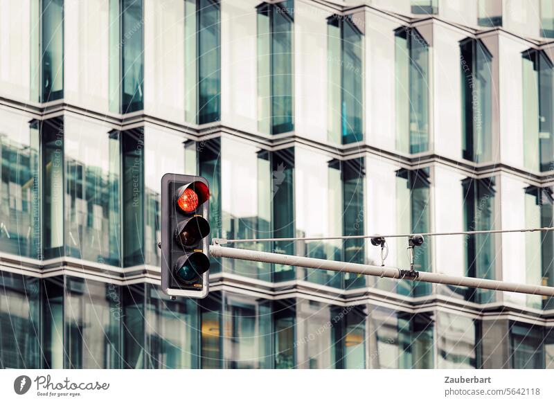 Ampel zeigt rot, vor moderner Fassade mit Glas und gezackten Linien Zickzack Träger Verkehr straßenverkehr halten anhalten stop Verkehrszeichen Stadt Hauptstadt