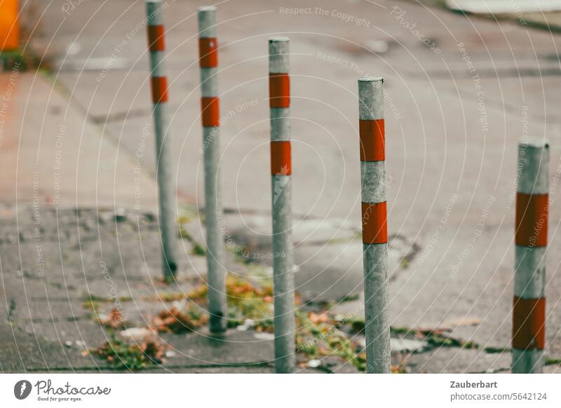 Eine Reihe Pfosten mit roten Streifen auf dem Gehweg Pfahl Poller Straße Muster Linie aufgereiht stehen standhaft Fußgängerweg Schutz Sperre Sicherheit