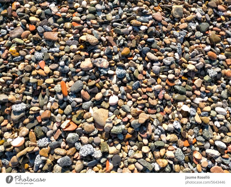 Hintergrund aus vielen kleinen Flusssteinen in verschiedenen Farben, Steine, die kürzlich vom Flusswasser benetzt wurden Geldmittel Boden Dach texturiert rio