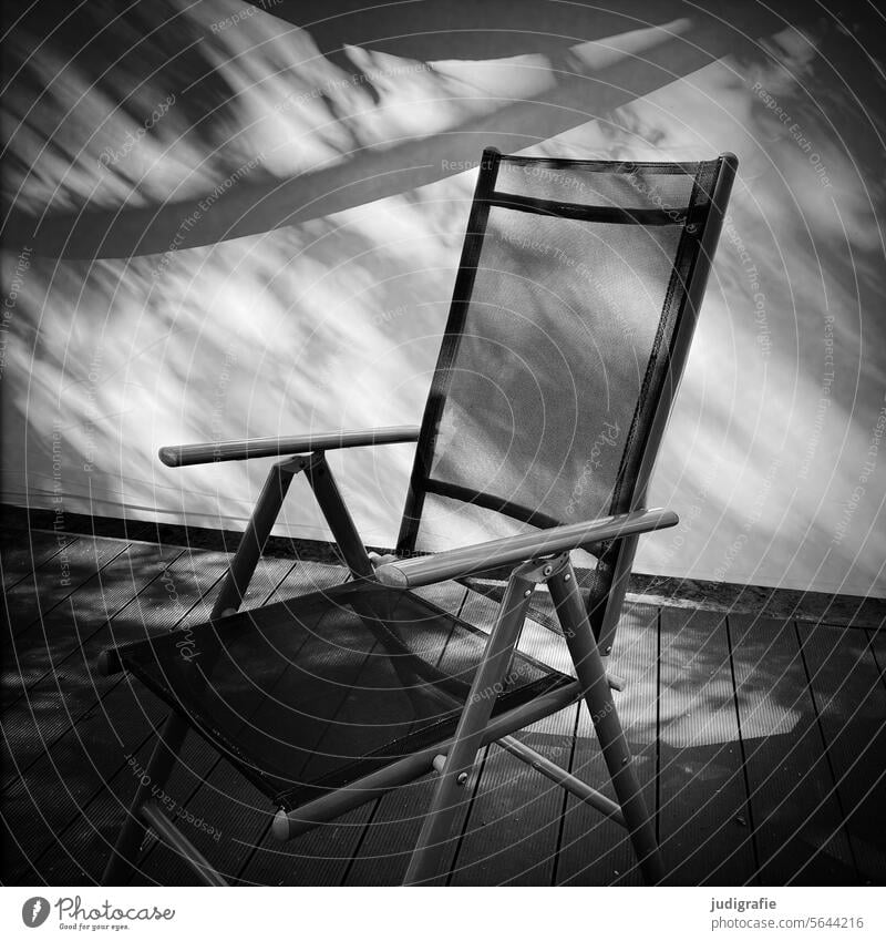 Gartenstuhl auf Terrasse Licht und Schatten Stuhl Gartenmöbel Sitzgelegenheit Klappstuhl Pause Ruhe ausruhen Urlaub leer Möbel Schwarzweißfoto Quadrat