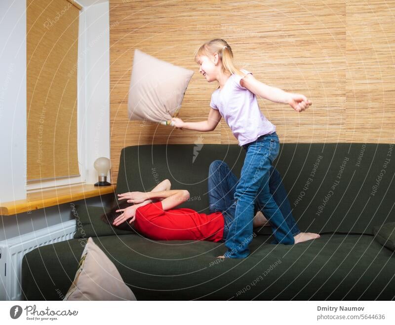 Geschwister mit Kissenschlacht auf einer Couch Halbgeschwister Aktivität attackieren schlagen Verhalten Junge Bruder Kind Kindheit Kinder Konflikt Liege