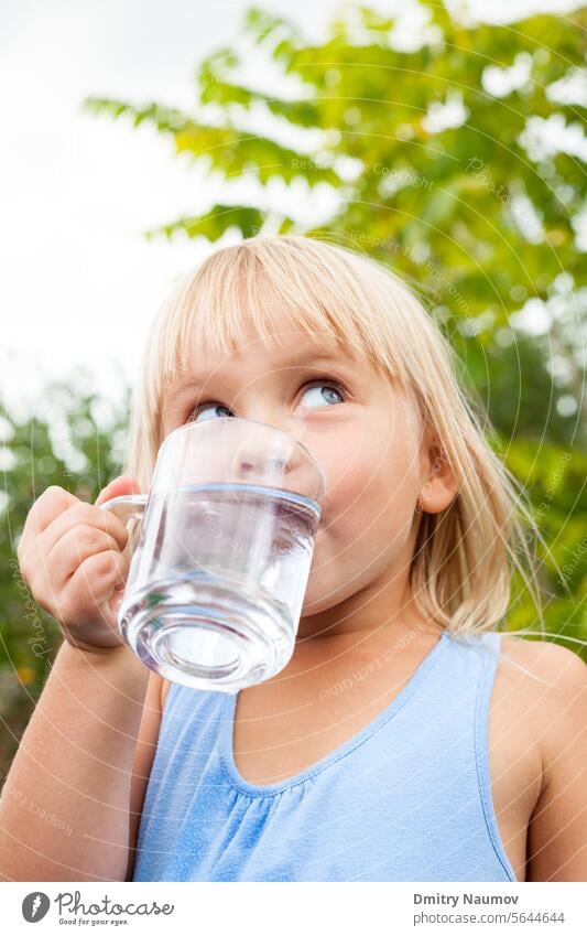 Kind trinkt Wasser im Freien 4-5 Jahre aqua Getränk blond blau Kaukasier Kindheit Sauberkeit übersichtlich Nahaufnahme Tasse trinken trinkbar frisch Garten
