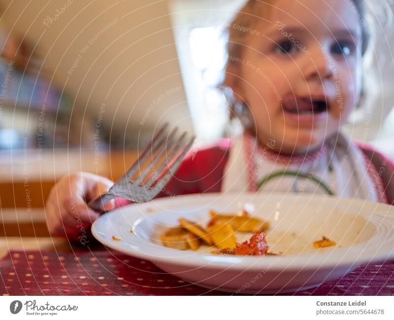 Kleinkind beim Essen. Lebensmittel Foodfotografie lecker Ernährung Gesunde Ernährung Farbfoto Kind rot Teller Zunge schlecken schmecken es schmeckt grün
