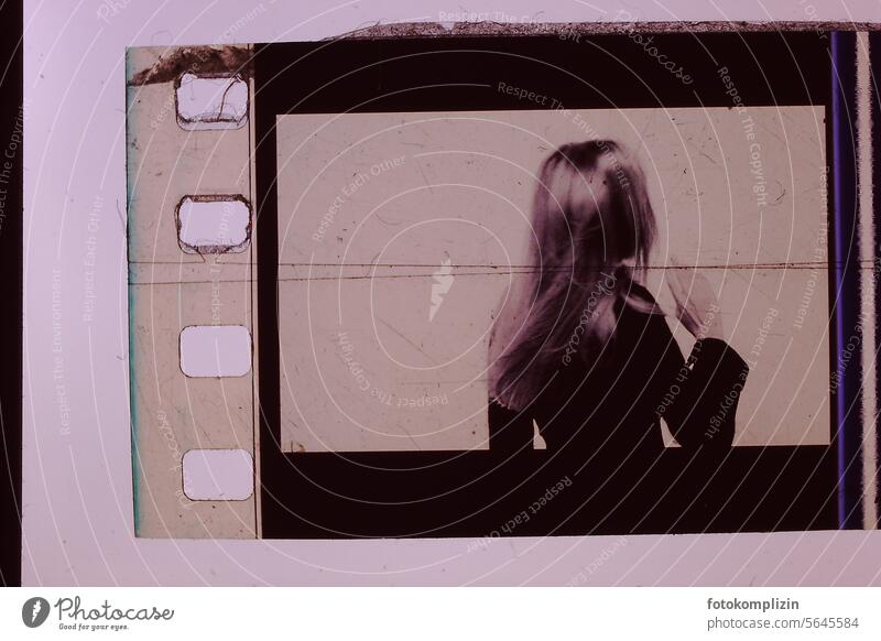 eine junge Frau mit einem negativen Haare rückenansicht retro Filmmaterial analog Nostalgie Fotografie Filmindustrie 35mm alt 35 Millimeter Film Kino Belichtung