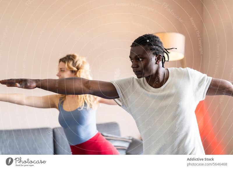 Vielfältiges Duo übt gemeinsam Yoga im Haus üben Vielfalt Übung Fitness Gesundheit Konzentration Pose im Innenbereich Wellness Gleichgewicht Harmonie Lifestyle