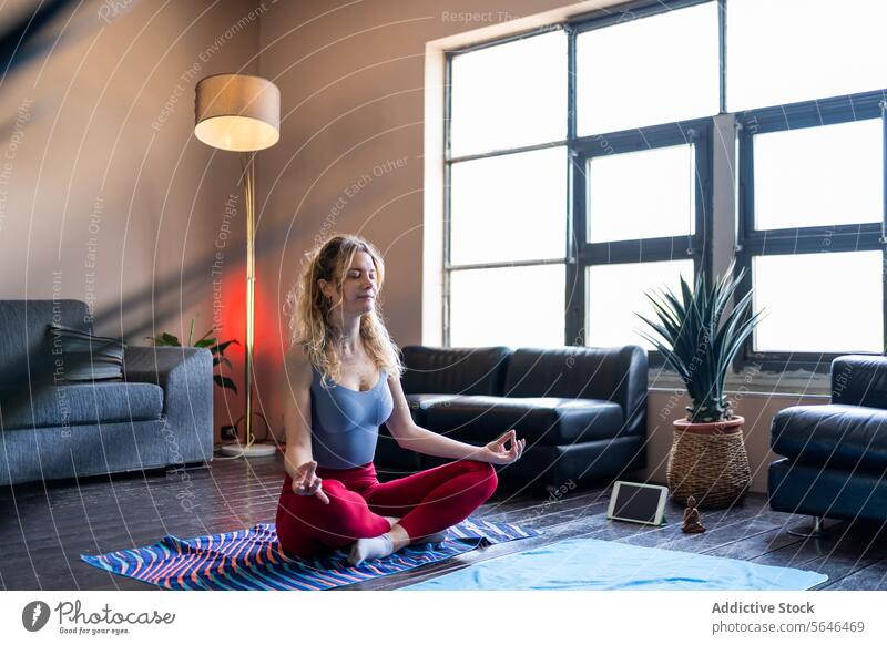 Frau übt Yoga zu Hause mit Sonnenlicht Meditation heimwärts Wohnzimmer Gelassenheit Pose Wellness Gesundheit Fitness Windstille Frieden üben im Innenbereich