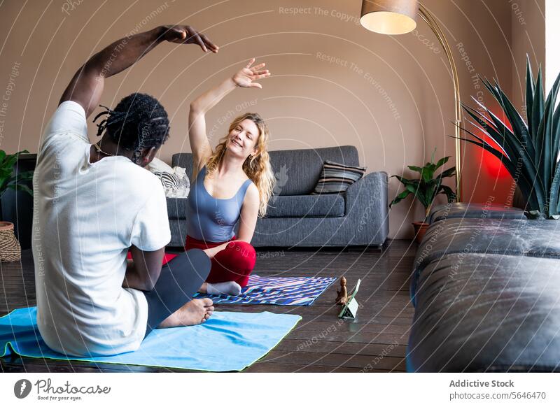 Paar übt gemeinsam Yoga in einem gemütlichen Wohnzimmer heimwärts Wellness Übung Fitness Gesundheit Hobby im Innenbereich Mann Frau Zusammensein üben Unterlage