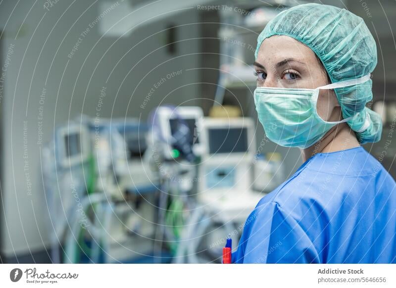 Chirurgin in Uniform mit medizinischer Maske und Kappe im Krankenhaus stehend Frau Mundschutz Arzt Klinik Arbeit Gesundheitswesen Verschlussdeckel Medizin