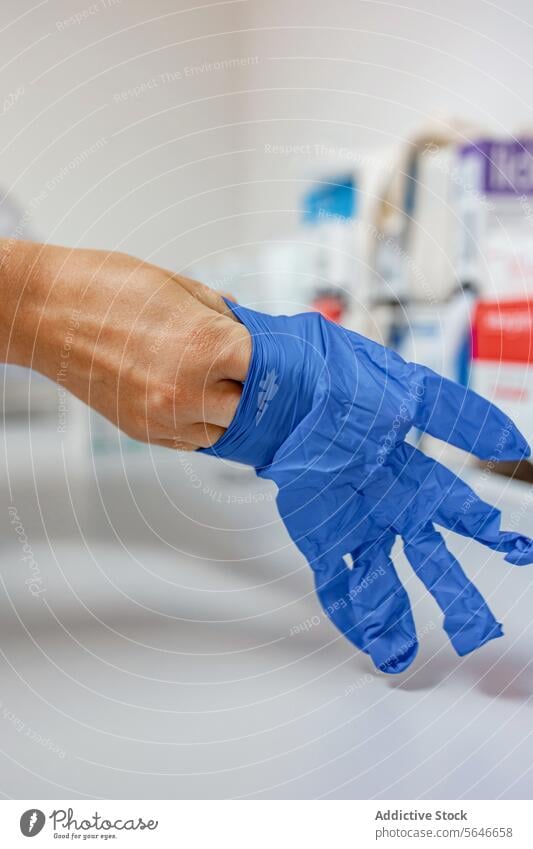Crop Sanitäter mit blauen Handschuhen in der Hand gegen verschwommene Person Arzt Krankenhaus Klinik medizinisch Gang manifestieren Medizin Gesundheitswesen