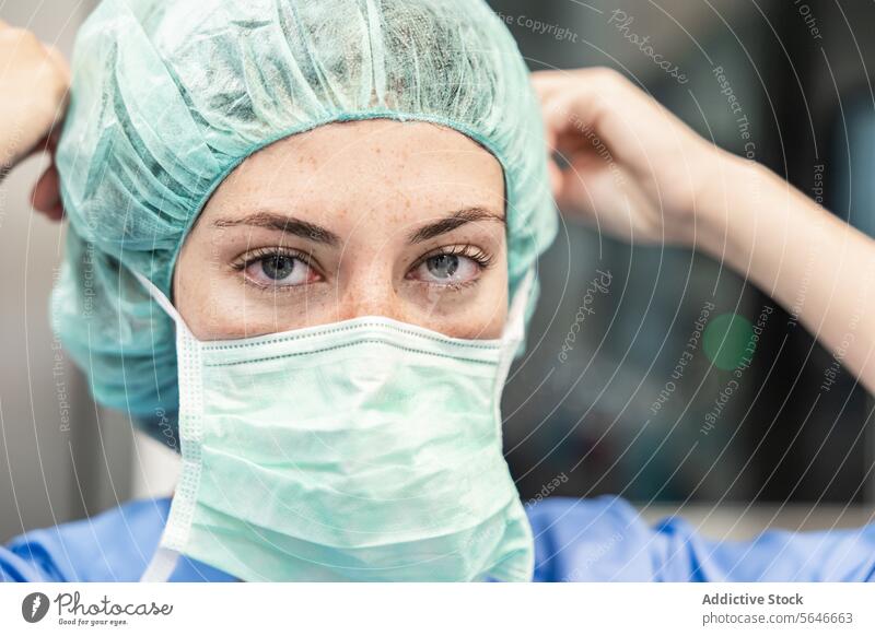 Chirurgin im Krankenhaus mit medizinischer Maske und Kappe Frau Mundschutz Uniform Arzt Klinik behüten Verschlussdeckel professionell Gesundheitswesen Medizin