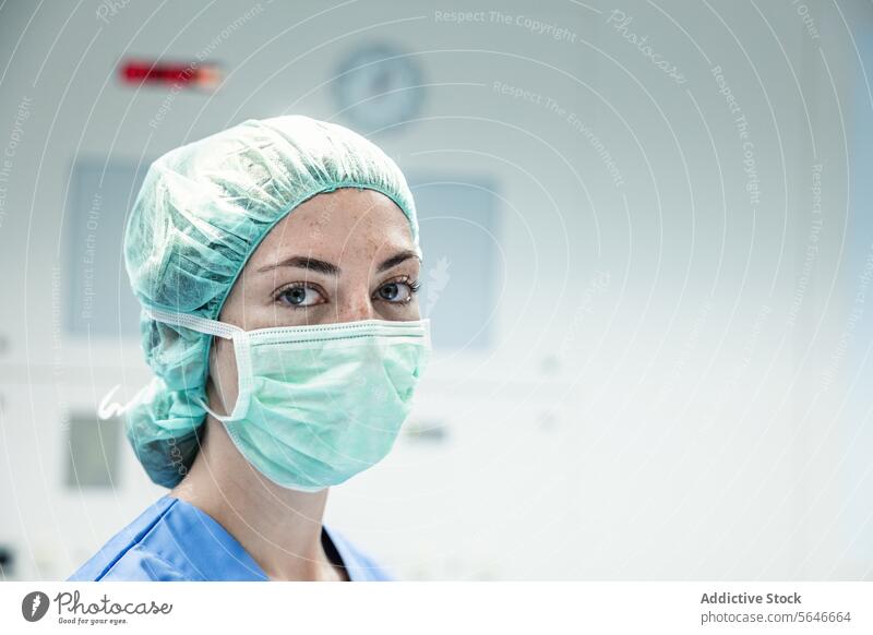Ärztin mit Schutzmaske und Kappe schaut in die Kamera Frau Mundschutz Krankenhaus Chirurg Arzt Klinik behüten Uniform Gesundheitswesen Verschlussdeckel