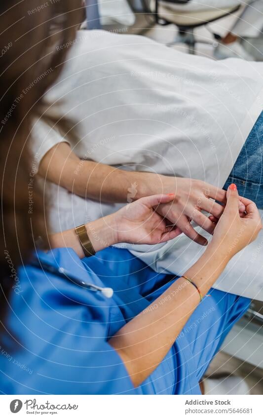 Unerkennbare Ärztin hält die Hand eines unscharfen männlichen Patienten, der auf dem Bett liegt Mann geduldig Frau Arzt Händchenhalten Uniform prüfen