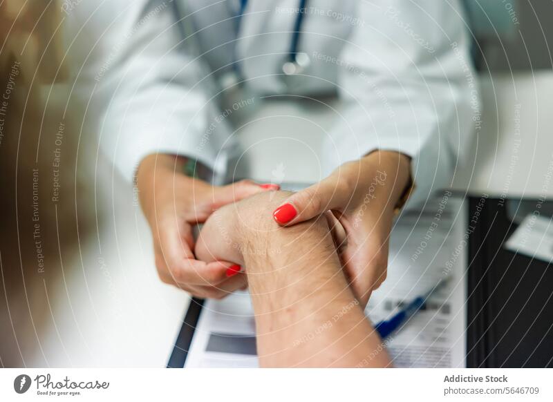 Unbekannte Ärztin untersucht die Hand eines anonymen Patienten am Konsultationstisch Frau Arzt Stethoskop Klinik geduldig prüfen Puls Tisch Krankenhaus
