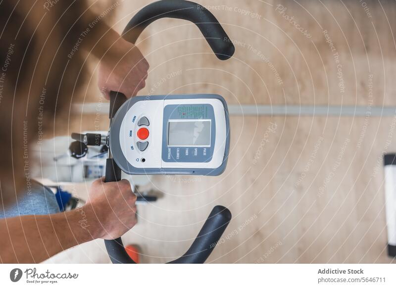 Crop unerkennbar Person mit Fitness-Heimtrainer Zyklus Übung Fahrrad Training Gerät physisch Maschine Gesundheitswesen elektrisch Aktivität Stock Sport