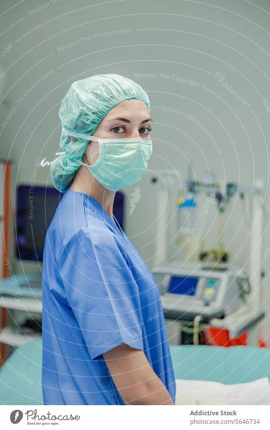 Chirurgin in Uniform mit medizinischer Maske und Kappe im Krankenhaus stehend Frau Mundschutz Arzt Klinik Arbeit Gesundheitswesen Verschlussdeckel Medizin