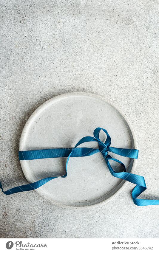 Ansicht von oben Minimalistische Ostertischdekoration Ostern minimalistisch Tischdekoration blaue Schleife Betonkulisse Einfachheit Textur stylisch raue Textur