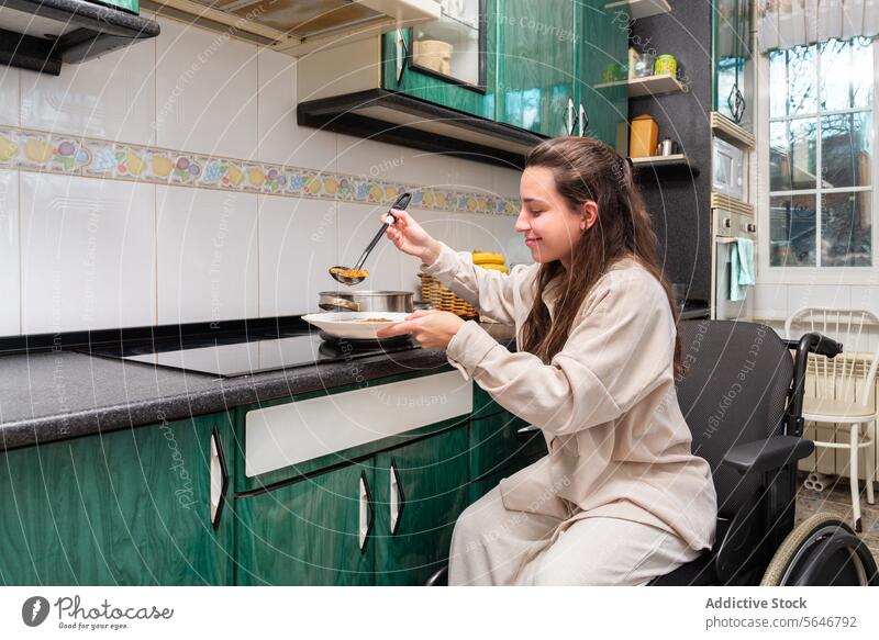 Unabhängiges Leben: Frau im Rollstuhl serviert Essen Mahlzeit Servieren Selbstständigkeit Küche Gesundheit Lächeln Selbstbedienung angepasst Lifestyle Ernährung