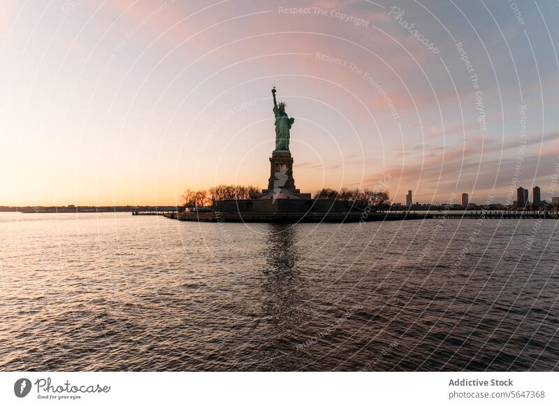 Freiheitsstatue am Ufer unter dem Himmel bei Sonnenuntergang Statue Denkmal Wahrzeichen amerika USA Vereinigte Staaten Fluss New York State Rippeln Revier