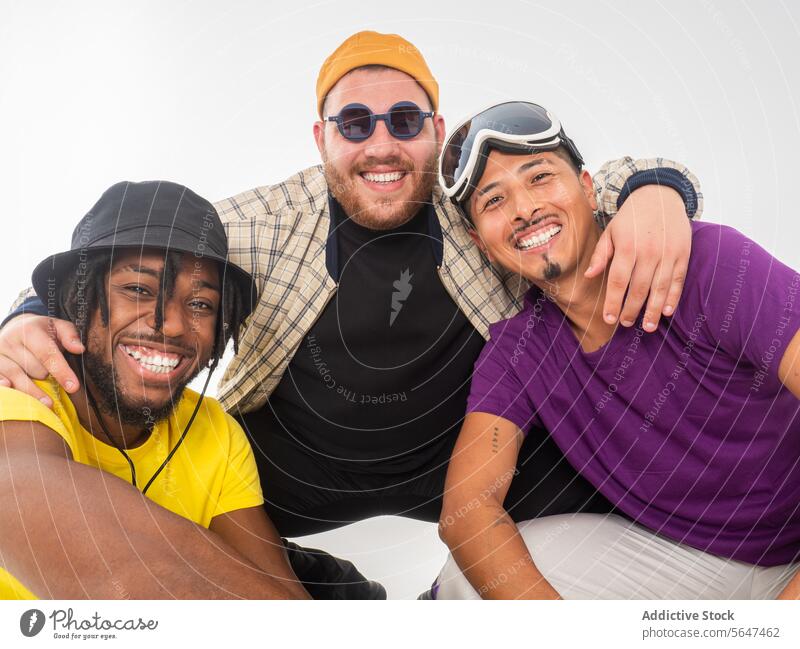 Drei glückliche Freunde genießen ein zwangloses Beisammensein Glück Freundschaft lässig Männer Lächeln heiter Umarmen Kameradschaftlichkeit weißer Hintergrund