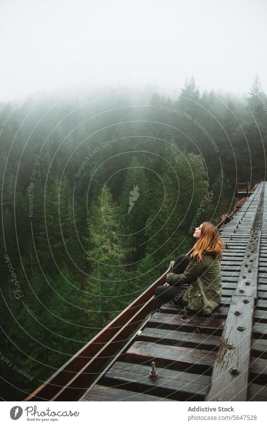 Nachdenkliche Frau auf nebliger Waldbahn Eisenbahn Nebel Einsamkeit Kontemplation Reflexion & Spiegelung Immergrün Vancouver Island British Columbia Kanada