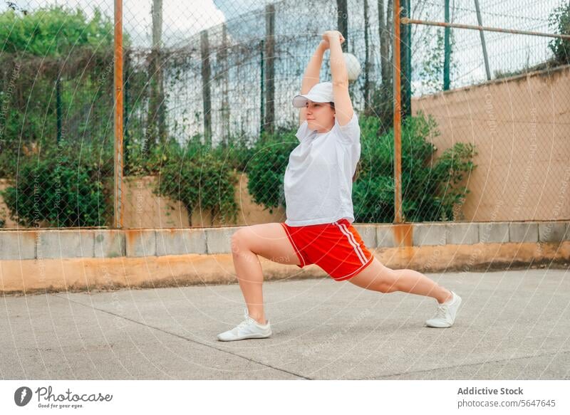 Aktive Frau bei einer Dehnungsübung im Freien strecken Übung Sportbekleidung Gesundheit Fitness Lifestyle Tennisplatz aktiv körperliche Aktivität Training