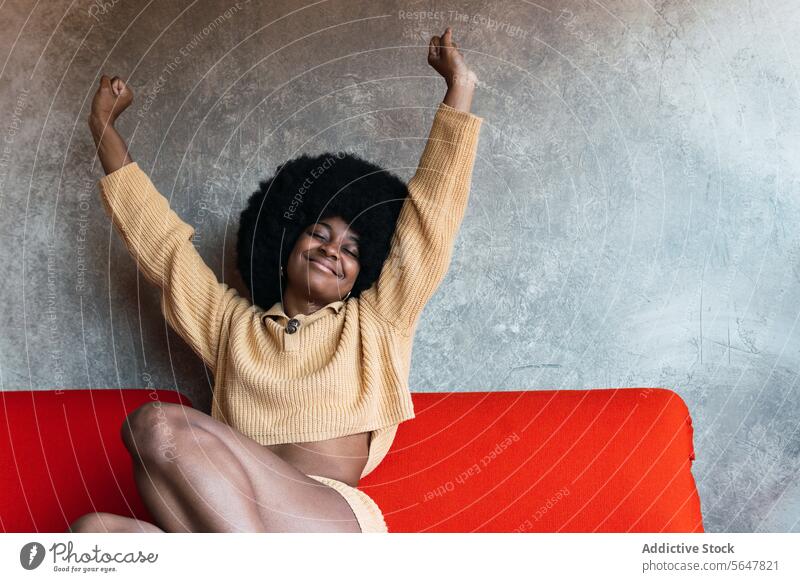 Lächelnde schwarze Frau, die sich nach dem Aufwachen streckt Dehnung aufwachen heimwärts Wochenende sich[Akk] entspannen Komfort genießen Arme hochgezogen