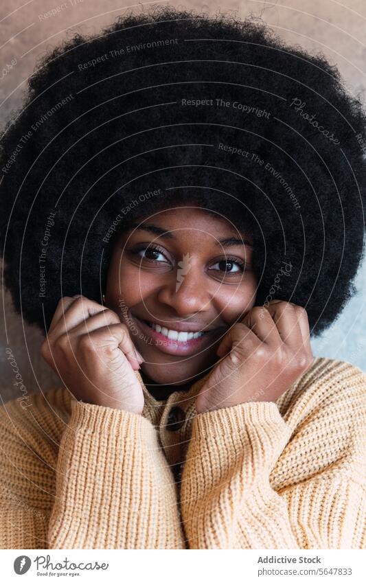 Lächelnde schwarze Frau mit geschlossenen Augen Afro-Look heiter Pullover Individualität Persönlichkeit Glück Vorschein Afroamerikaner Frisur jung Stil