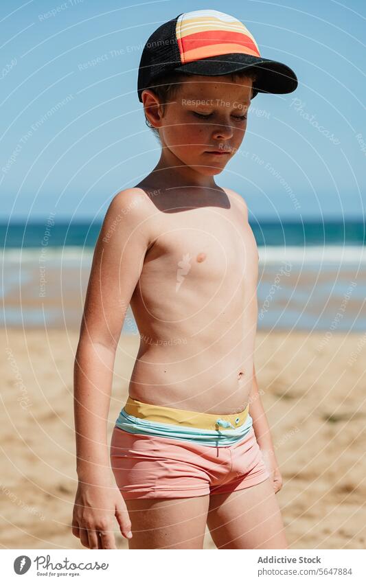 Nachdenklicher Junge am Strand mit Baseballmütze Kind beschaulich nachdenklich jung Sand Meer Blauer Himmel Badebekleidung Verschlussdeckel Sommer MEER