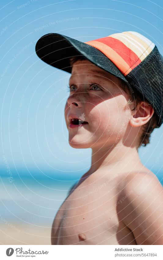 Nachdenklicher Junge am Strand mit Baseballmütze Kind beschaulich nachdenklich jung Sand Meer Blauer Himmel Badebekleidung Verschlussdeckel Sommer MEER