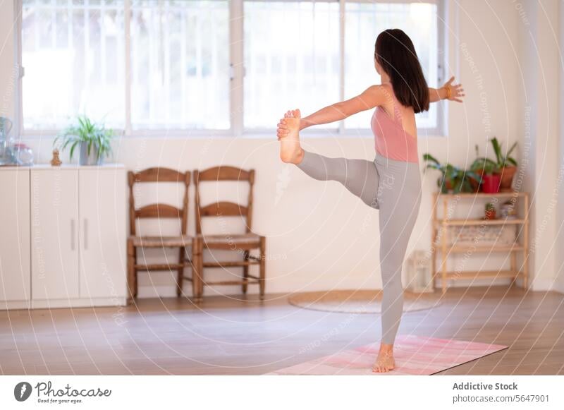 Fitte, nicht wiederzuerkennende Frau, die beim Training Yoga übt üben Gleichgewicht Dehnung passen Sportkleidung Lektion beweglich Asana Gesunder Lebensstil