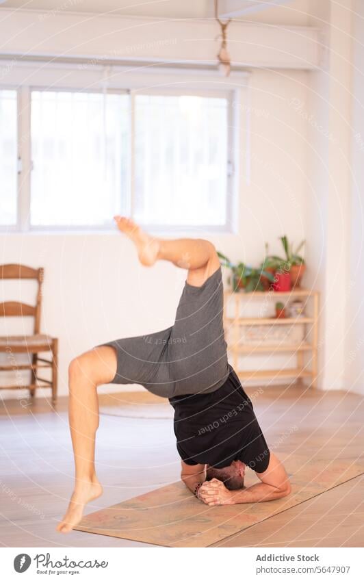 Flexibler, nicht erkennbarer Mann übt Yoga im Studio üben Handstand beweglich passen Training ausführen Sportbekleidung Gleichgewicht Raum männlich