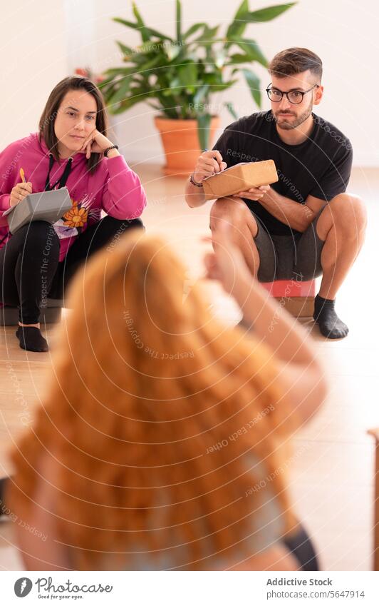 Positive Gruppe von Yogaschülern, die im Schulungszentrum auf dem Boden sitzen Schüler Praktiker Stock Training Zentrum Atelier positiv Lächeln üben Wellness
