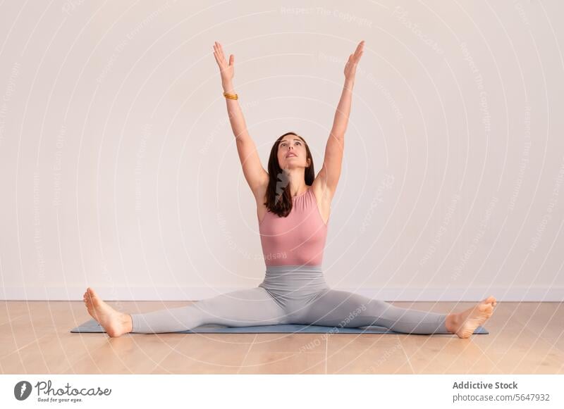 Fitte Dame, die sich während der Yogapraxis auf der Matte dehnt Dehnung sitzen üben Frau Training Sitzung Unterlage passen Asana schlank Wohlbefinden beweglich