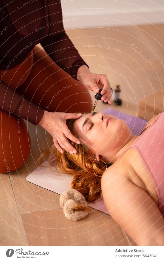 Eine Frau trägt ätherisches Öl auf das Gesicht eines Kunden im Studio auf bewerben Klient Kosmetikerin Schönheit Dame sich[Akk] entspannen Lügen Sitzung Yoga