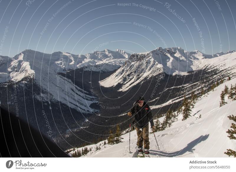 Person beim Skifahren auf einem schneebedeckten Berg Skifahrer Berge u. Gebirge anonym aktiv Mast Rucksack Schnee Berghang Klarer Himmel Kanada Natur
