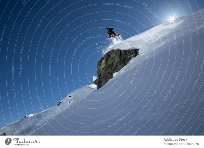 Aktive Person fährt Snowboard auf verschneitem Felsen Snowboarder springen furchtlos anonym Formation Schnee Landschaft Winter Feiertag Kanada deckend weiß