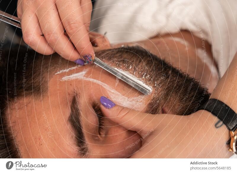 Von oben Ernte unerkennbar Hände der weiblichen Friseur rasieren männlichen Kunden den Bart mit Rasiermesser im Salon Rasieren Gerades Rasiermesser Vollbart