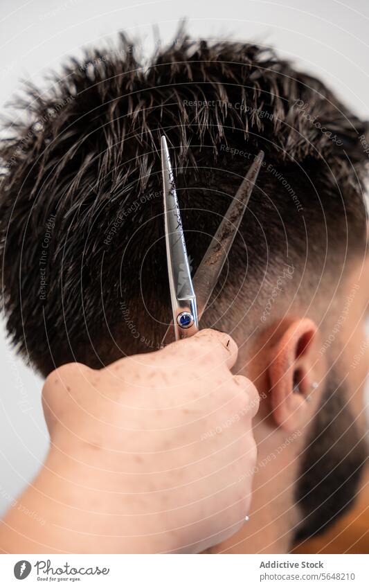 Abgeschnittene, nicht erkennbare Hände einer Friseurin, die die Haare eines männlichen Kunden mit einer Schere im Salon schneiden Kamm Mann Behaarung Pflege