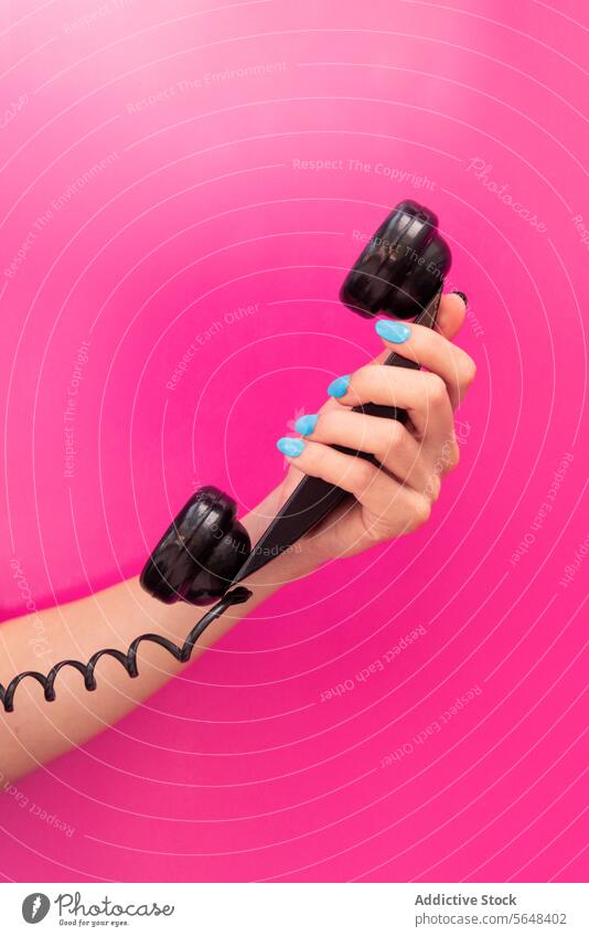Hand einer anonymen Frau, die einen Telefonhörer hält Beteiligung schwarz blauer Nagellack rosa Hintergrund pulsierend Mitteilung Anruf retro altehrwürdig Stil