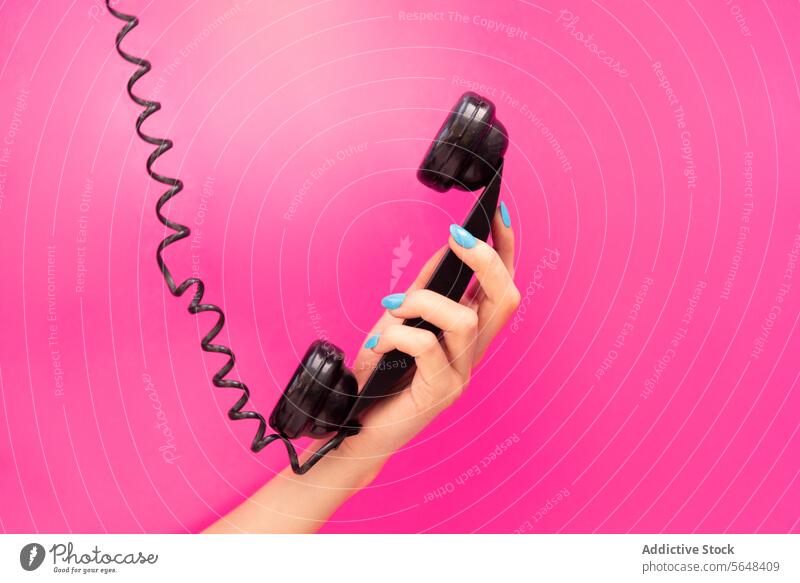 Hand einer anonymen Frau, die einen Telefonhörer hält Beteiligung schwarz blauer Nagellack rosa Hintergrund pulsierend Mitteilung Anruf retro altehrwürdig Stil