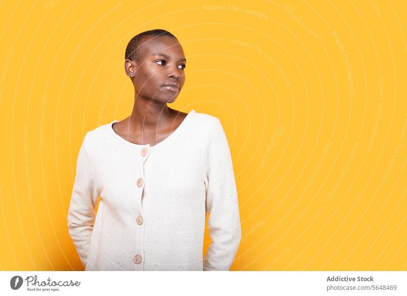 Selbstbewusste schwarze junge Frau isoliert auf gelbem Hintergrund selbstbewusst Porträt Stil vereinzelt ernst Emotion Textfreiraum Afroamerikaner Kurze Haare
