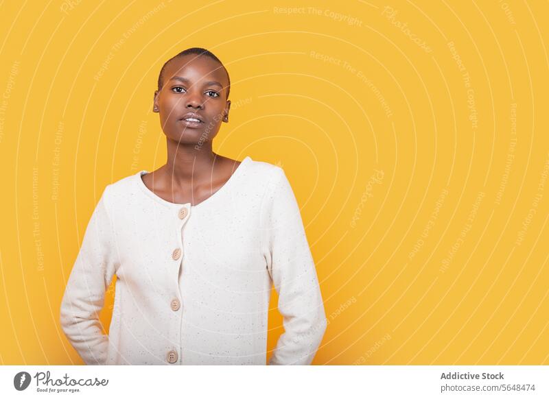 Selbstbewusste schwarze junge Frau isoliert auf gelbem Hintergrund selbstbewusst Porträt Stil vereinzelt ernst Emotion Textfreiraum Afroamerikaner Kurze Haare