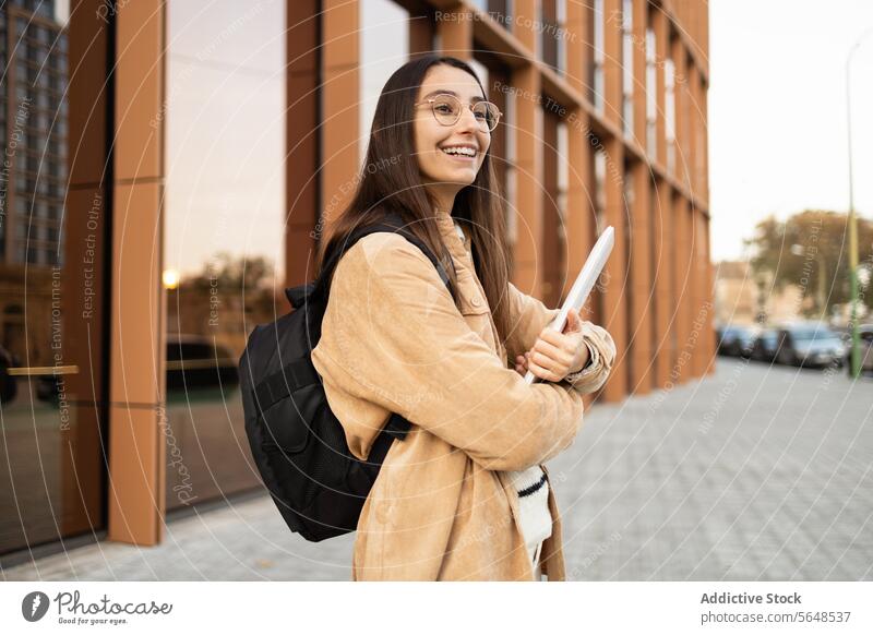 Lächelnder Student mit Rucksack vor dem College-Gebäude Frau Schüler Notebook heiter jung modernes Gebäude Bildung Hochschule Universität Campus Lifestyle